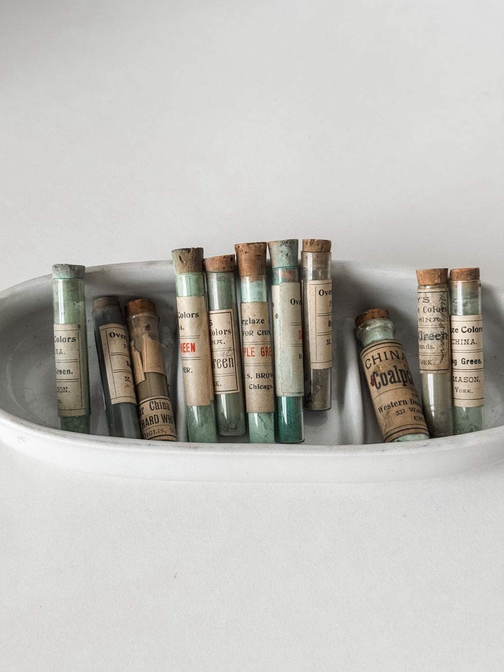 Set Of Glass Art Pigment Vials In Shades Of Green With Ironstone Vessel