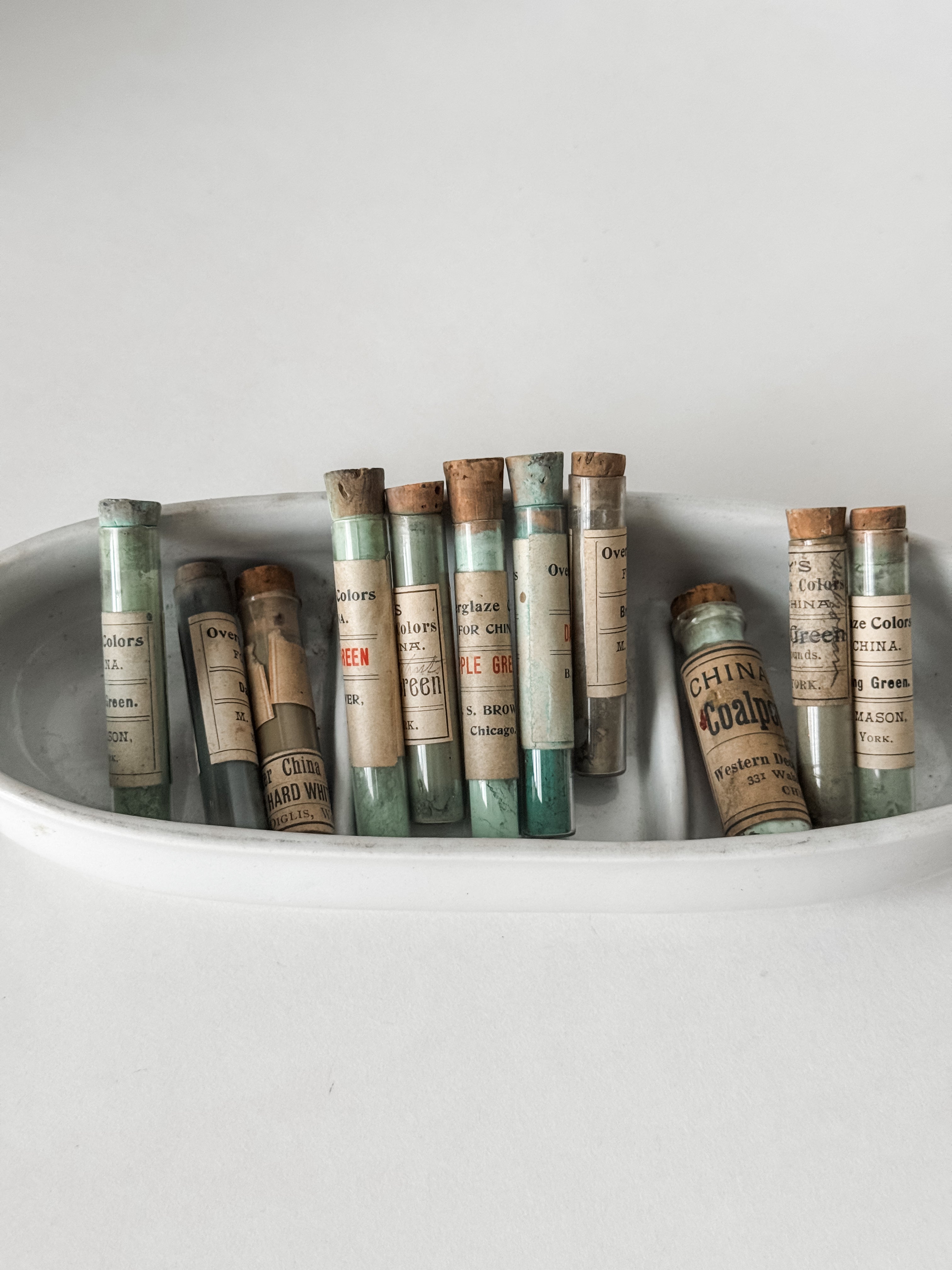 Set Of Glass Art Pigment Vials In Shades Of Green With Ironstone Vessel