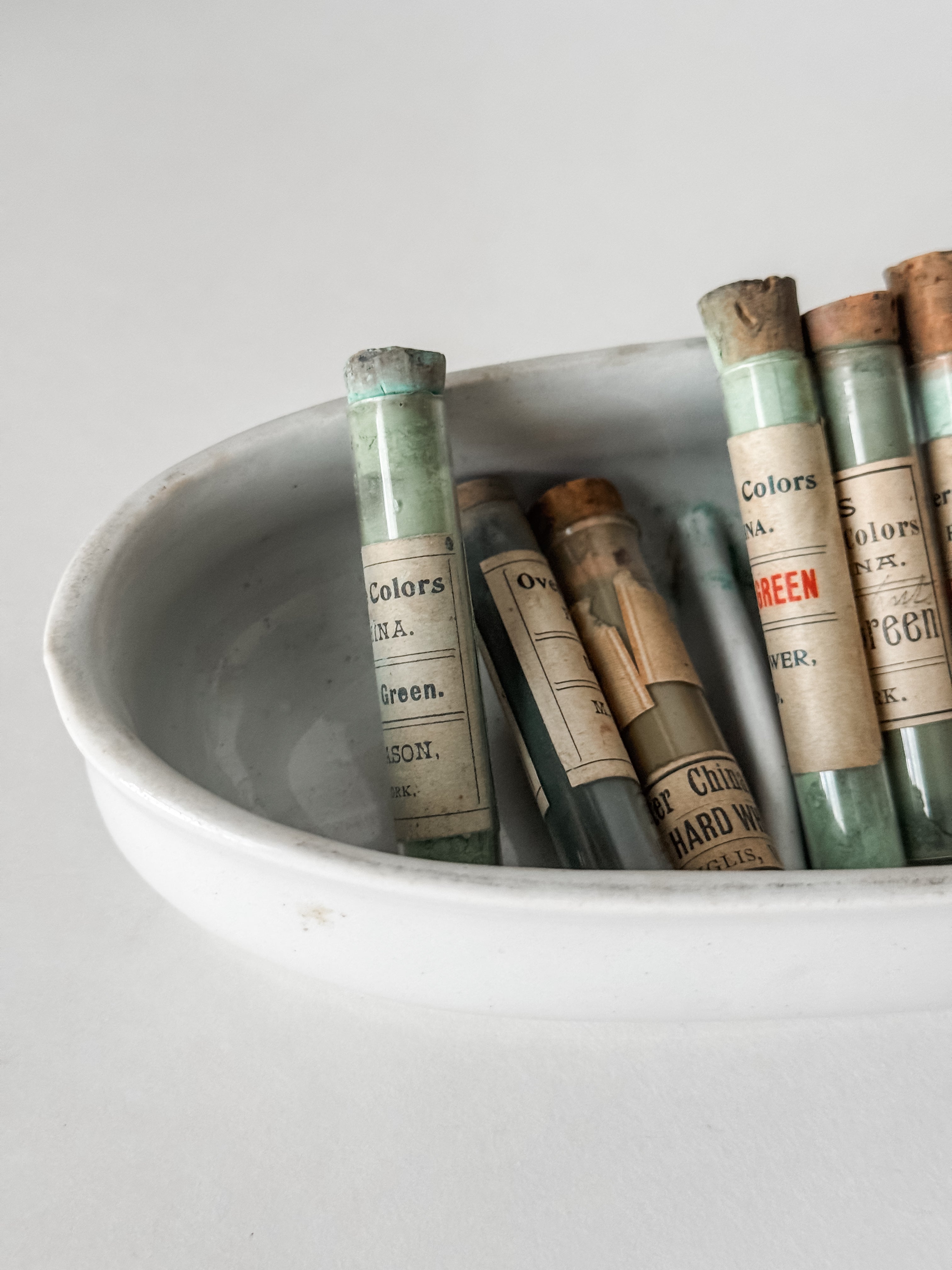 Set Of Glass Art Pigment Vials In Shades Of Green With Ironstone Vessel