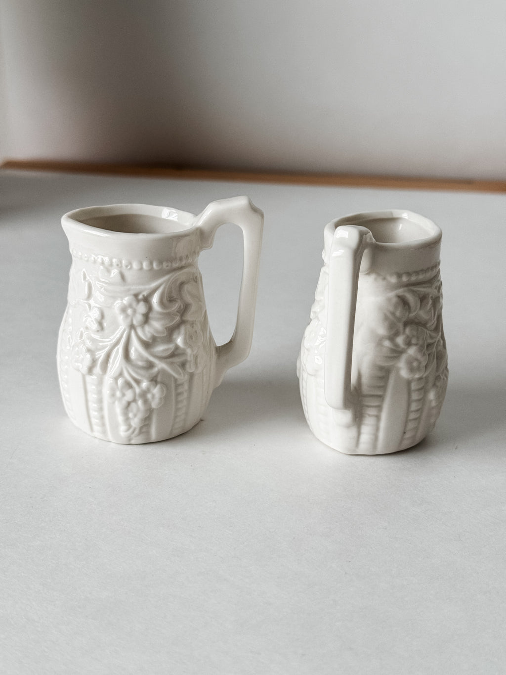 Small White Creamer With Handle And Raised Floral Details