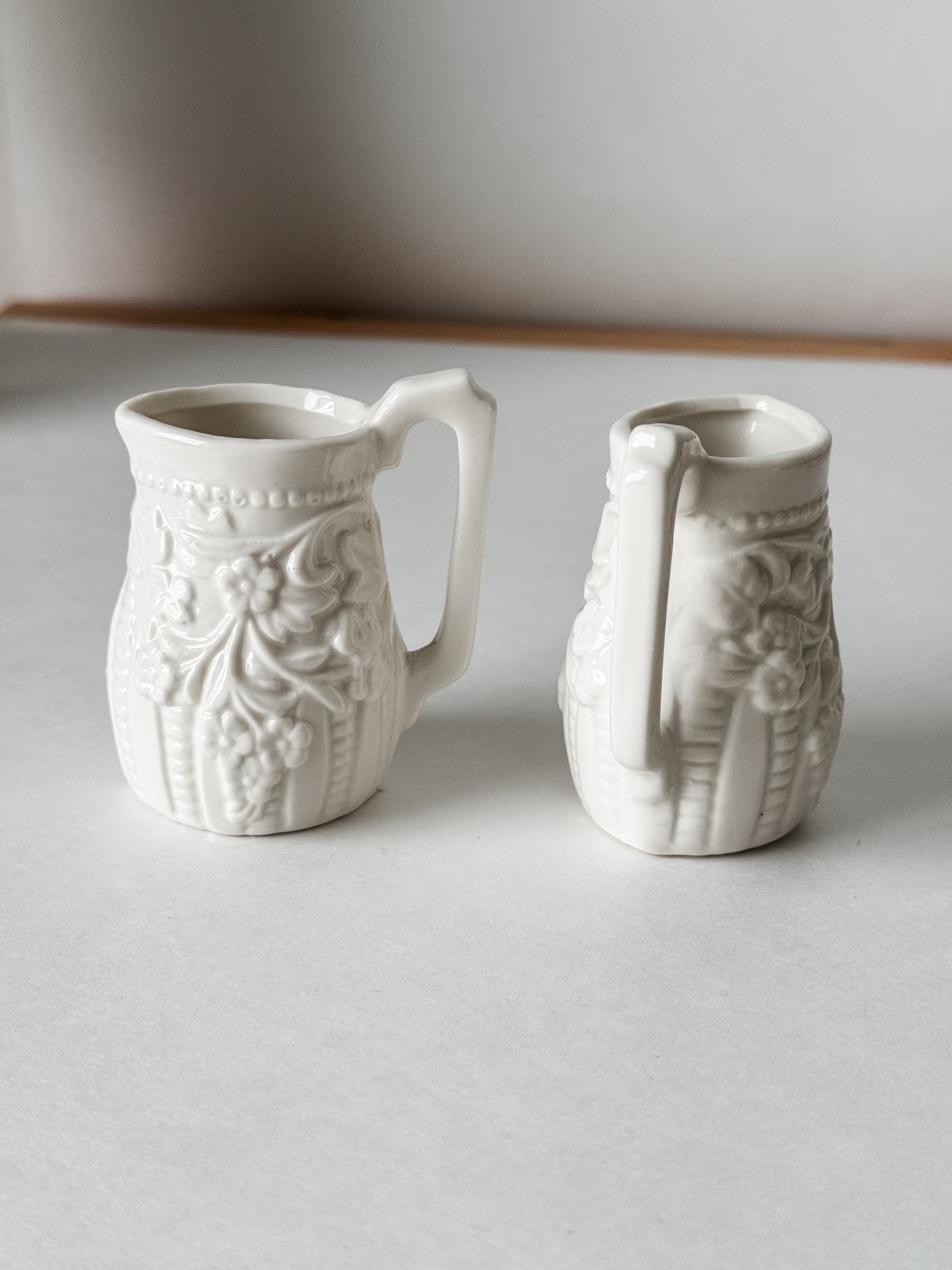 Small White Creamer With Handle And Raised Floral Details
