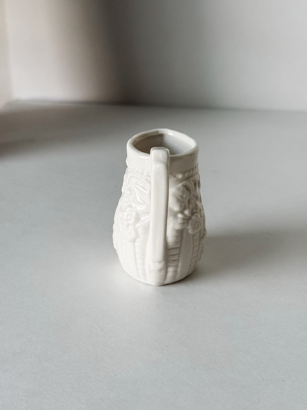 Small White Creamer With Handle And Raised Floral Details