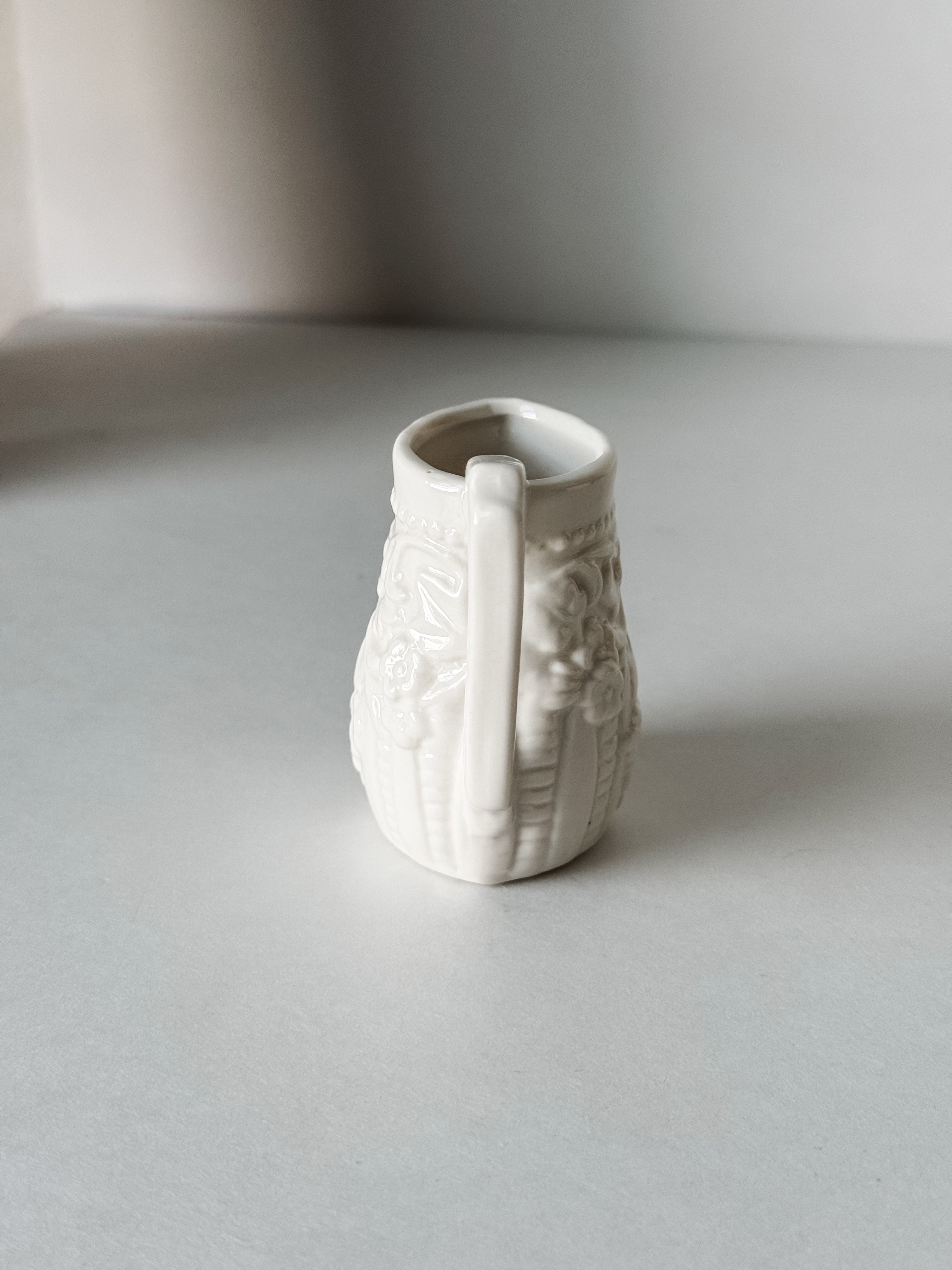 Small White Creamer With Handle And Raised Floral Details